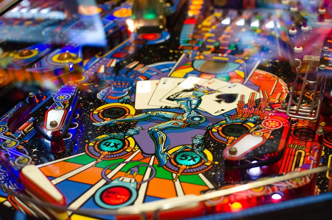 A glowing, fully-lit pinball machine playfield in a dark game room, with multiball in play and cabinet artwork illuminated by LED lighting